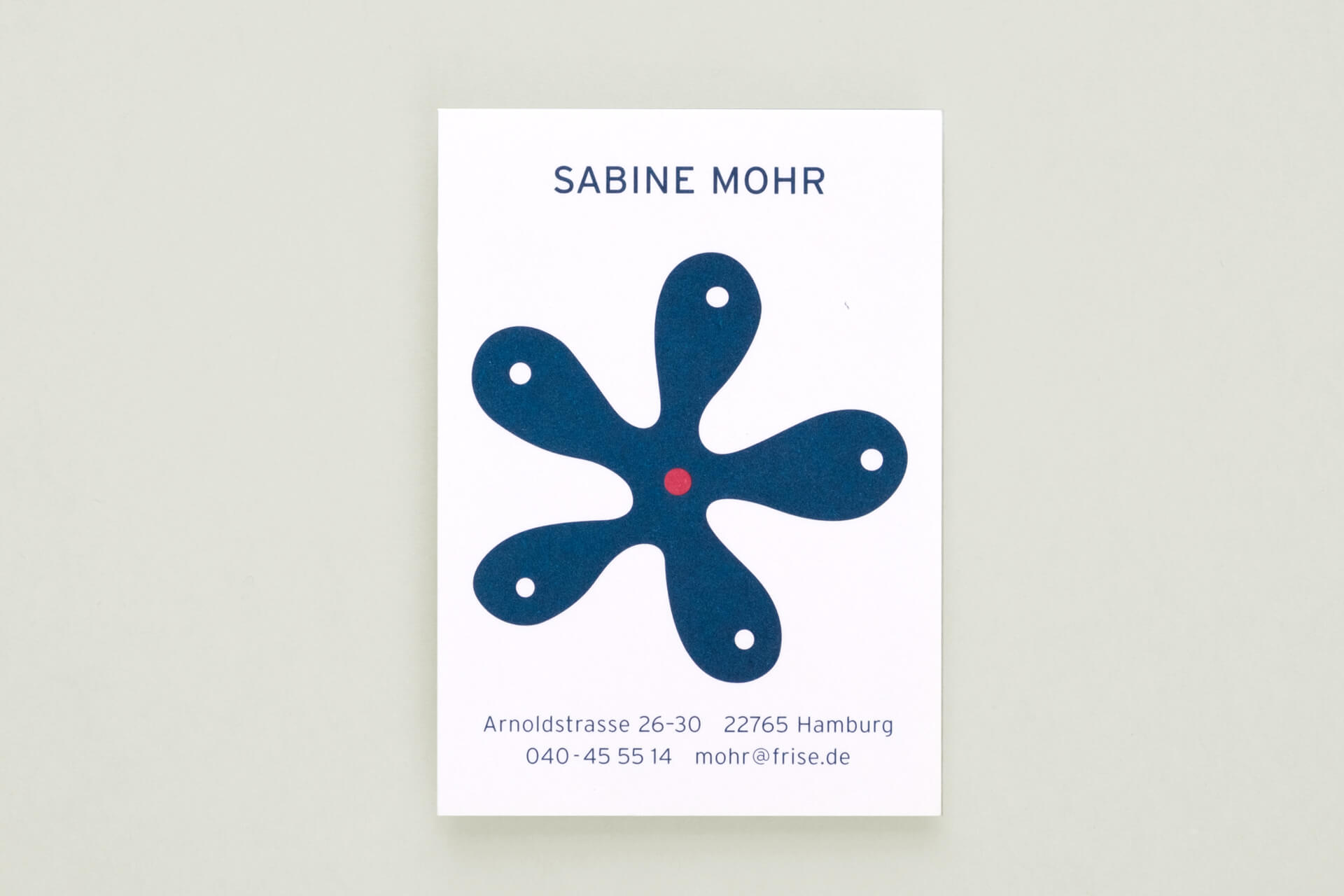 Ansicht einer Visitenkarte mit einem Logo in Form einer abstrakten fünf-fingrigen blauen Blume für eine Goldschmiedin