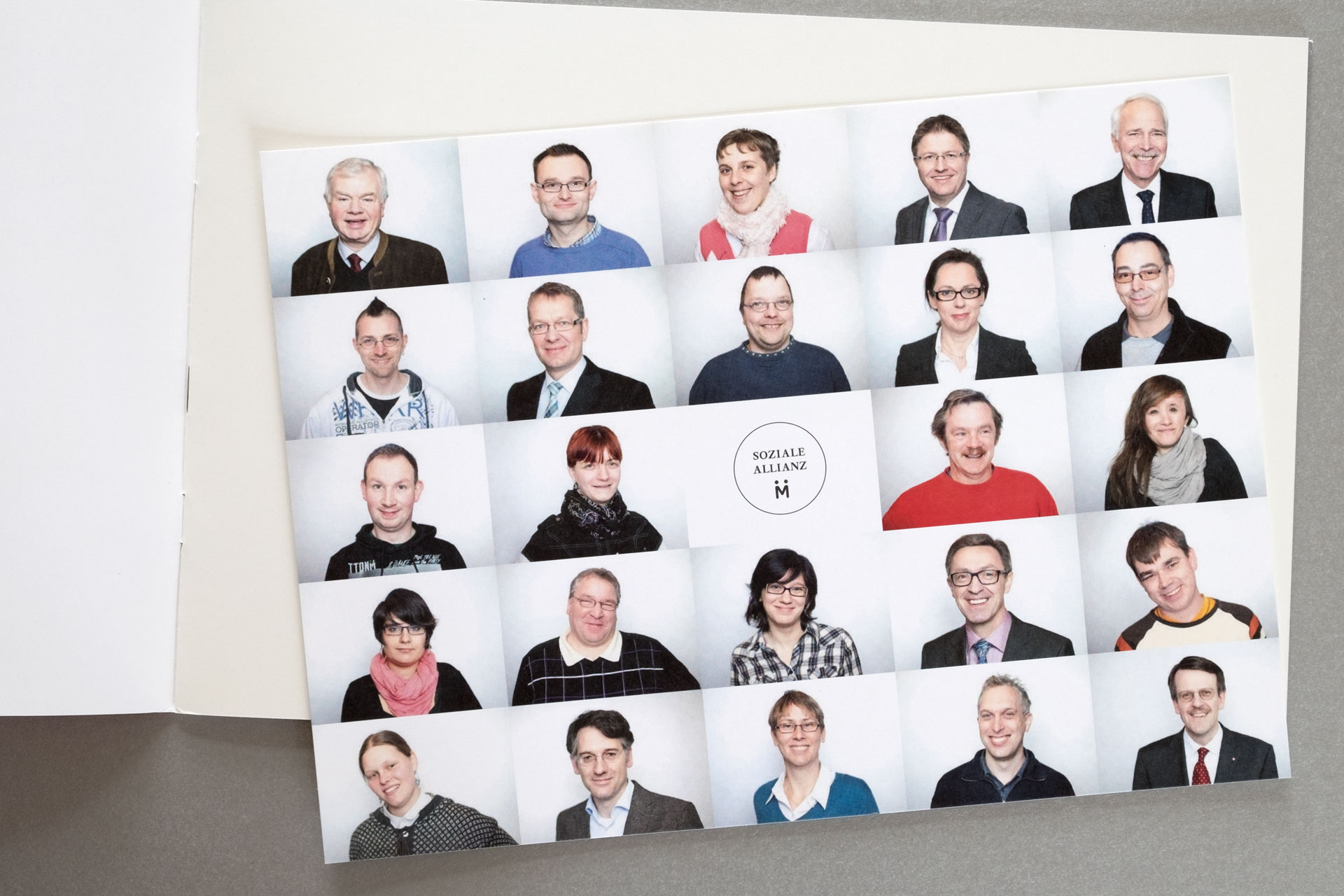 Einlegekarte im Format DIN 5. Darauf Portraits aller Unternehmer:innen und Gehandicapten der Sozialen Allianz.