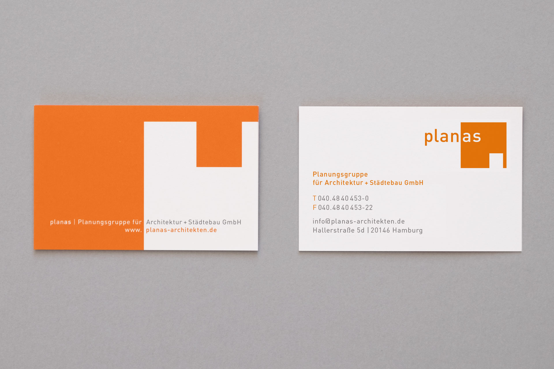 bbildung der Geschäftsausstattung (Visitenkarten) für Planas Architekten mit orangem Logo und dessen Negativform